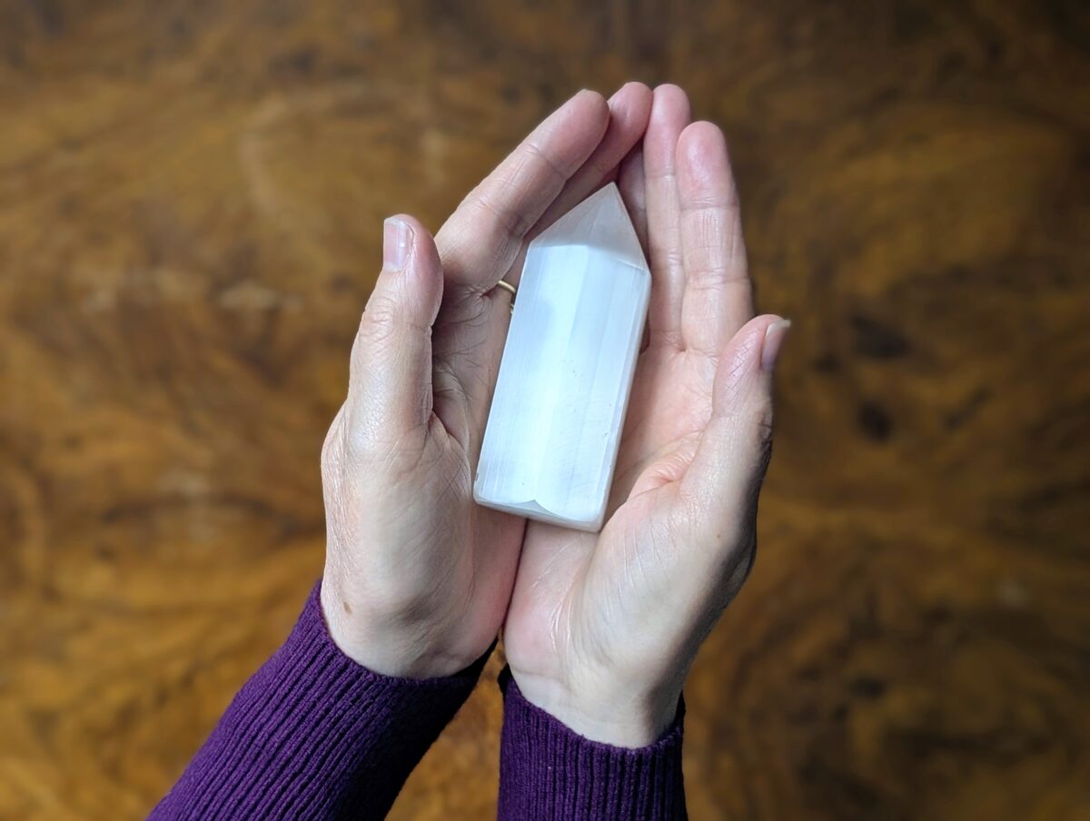 Hands cradling selenite