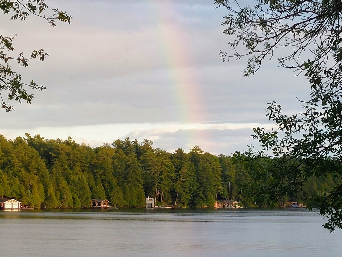 Rainbow over lake at dusk